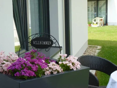 Willkommen Schild in einem Blumenkübel